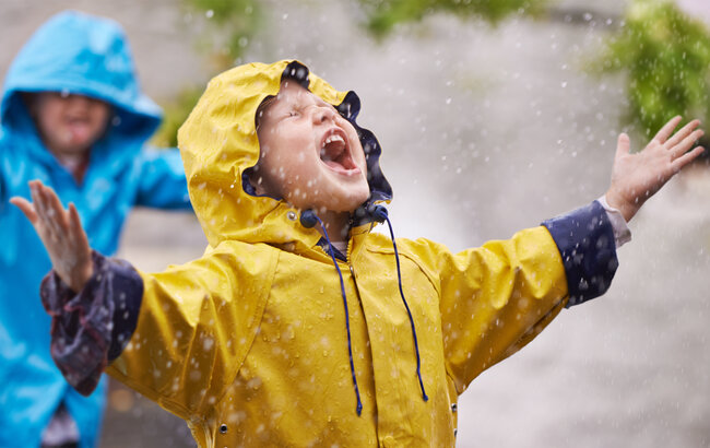 Dziecko czerpie radość z padającego deszczu